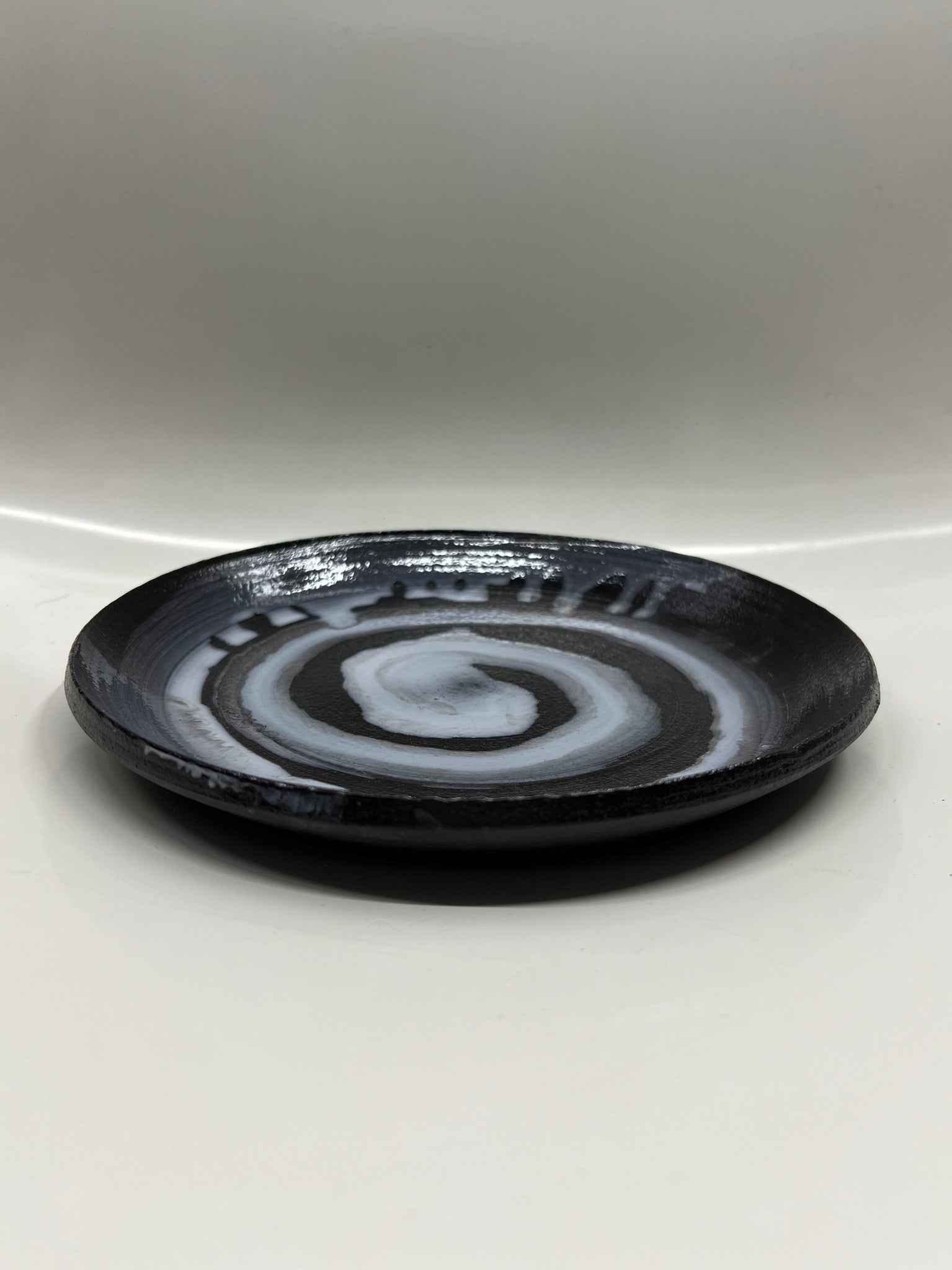 Swirl plate in black with white swirl by Fritz Adamski